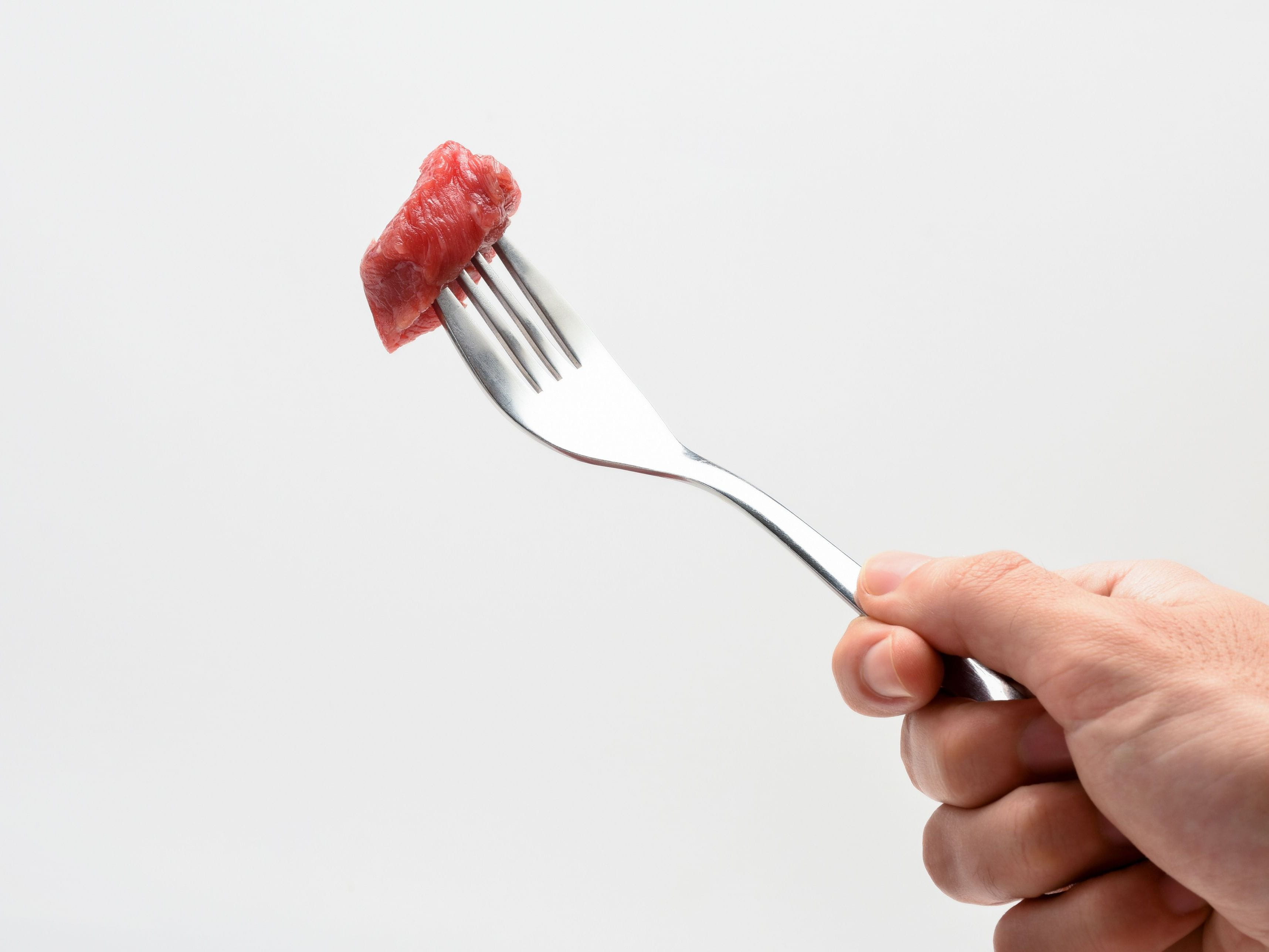 raw meat on fork