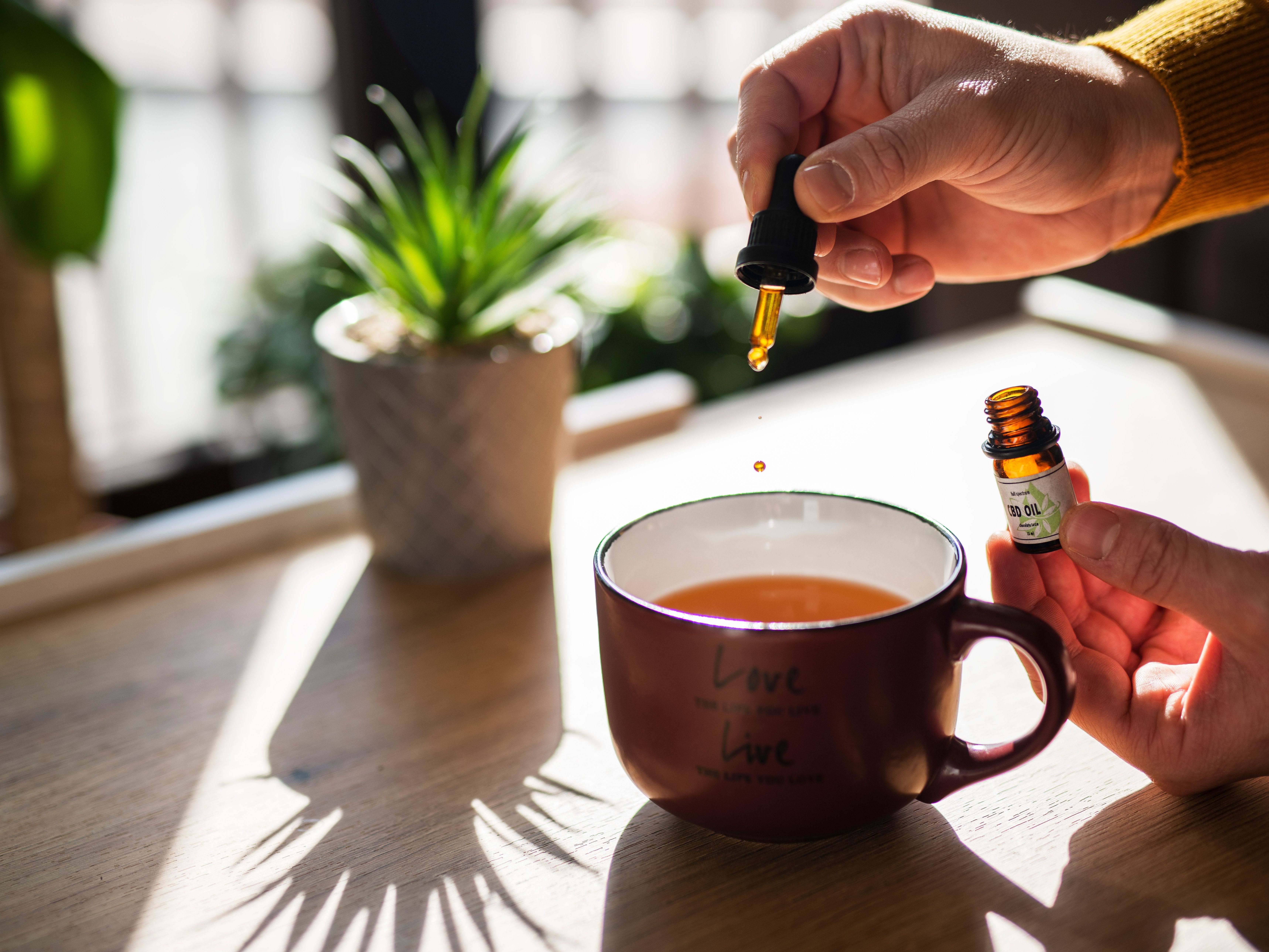 homeopathic remedy being dropped into a cup of tea