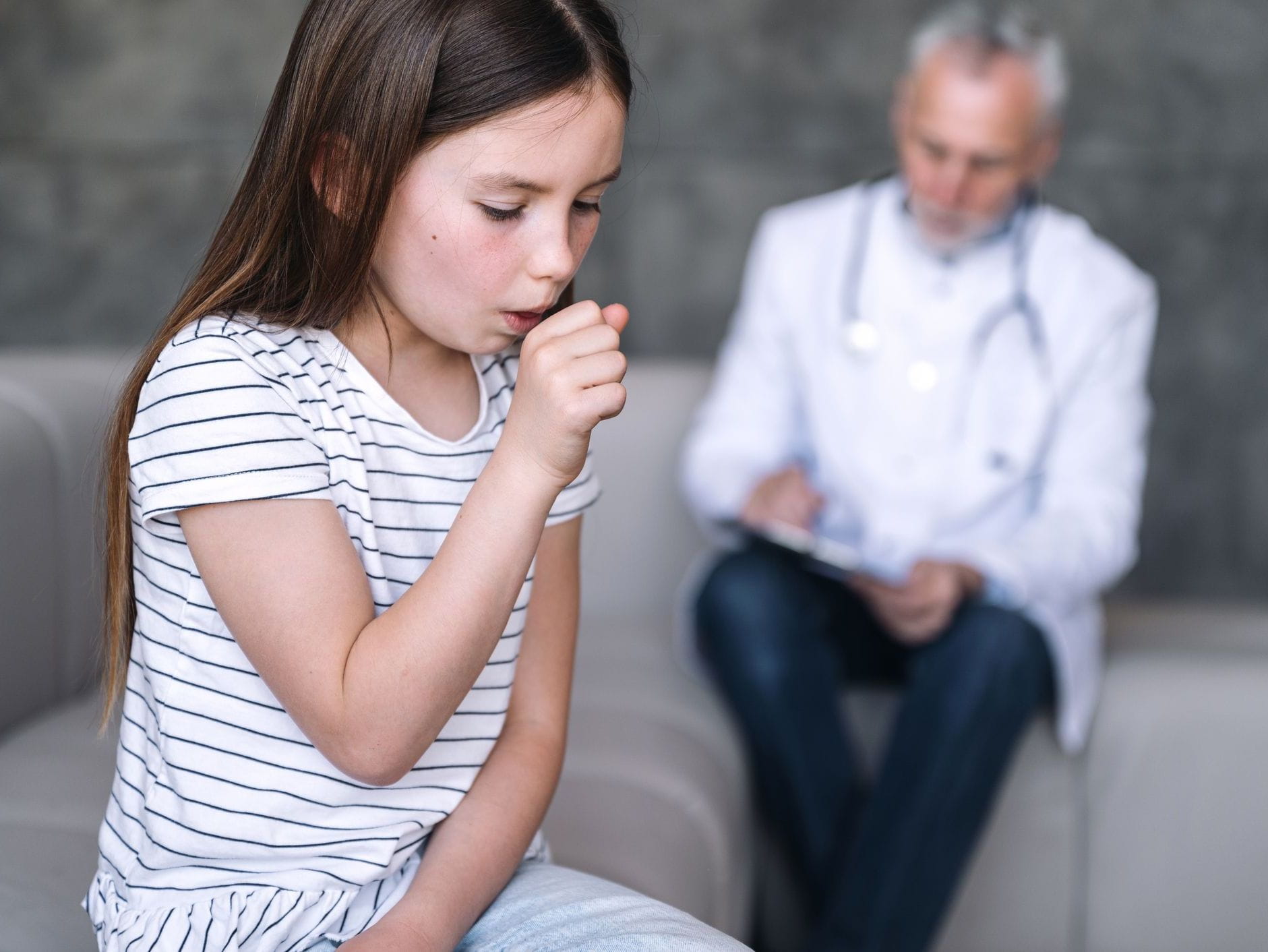 girl coughing in doctor's office