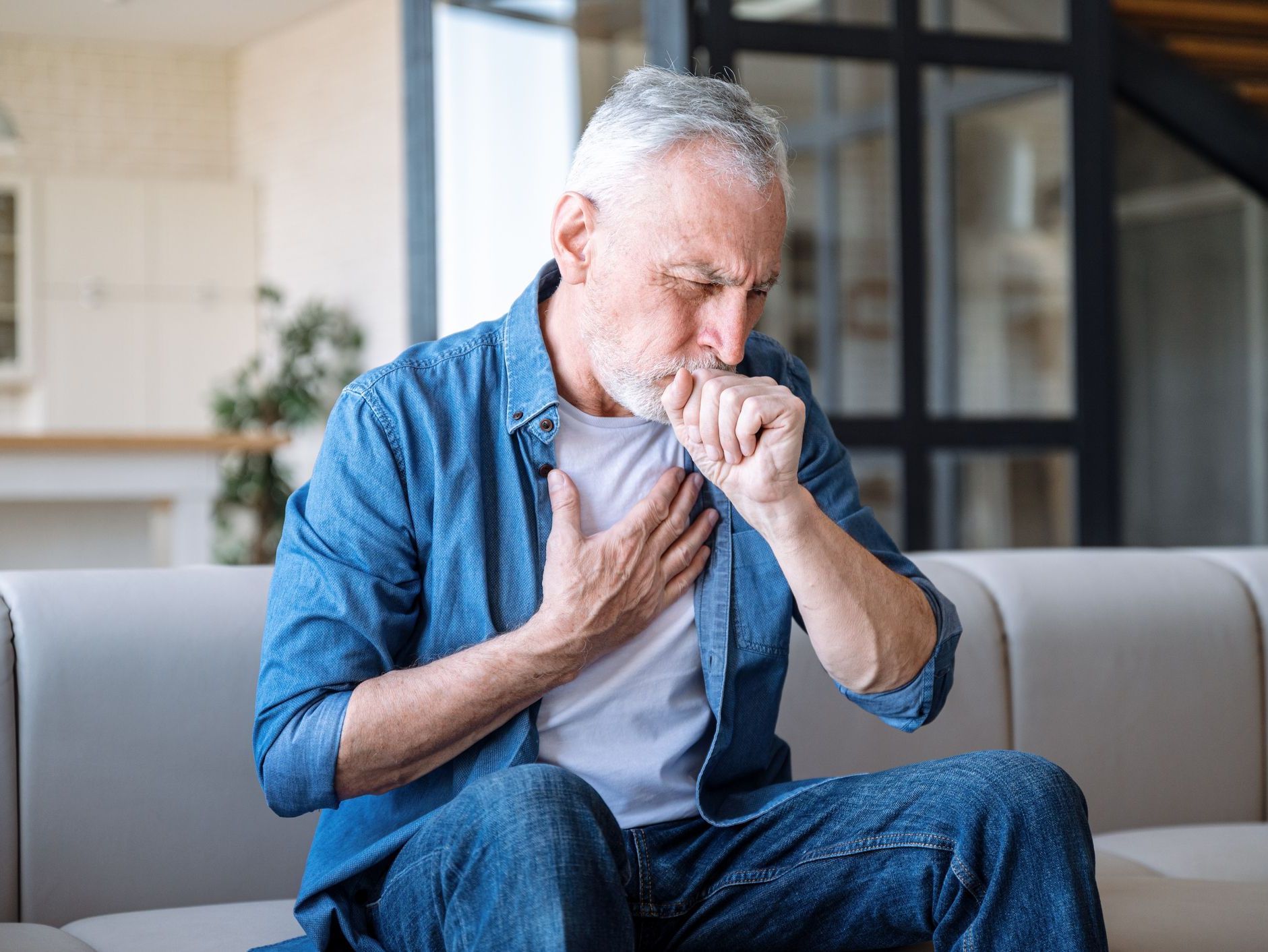 man holding chest and coughing