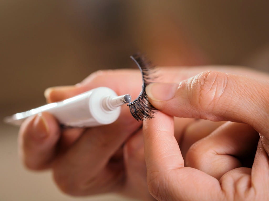 applying eyelash glue to false lashes