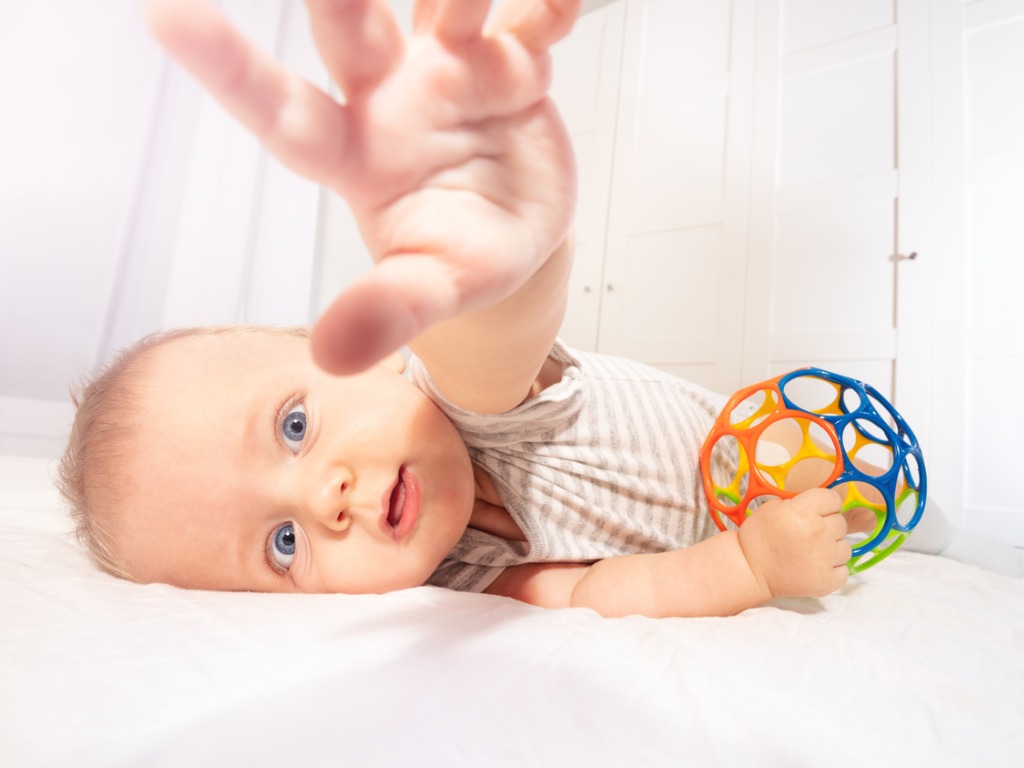 infant with a hand stretched to camera