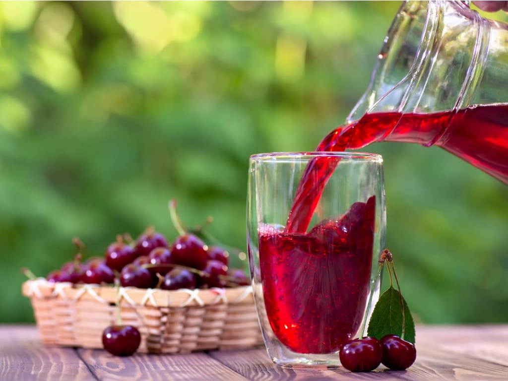 pouring cherry juice next to cherries