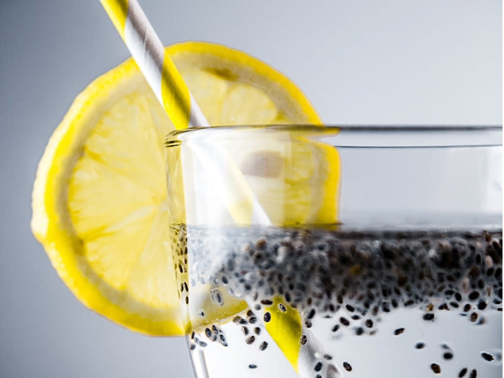 chia seeds in water with lemon and a straw