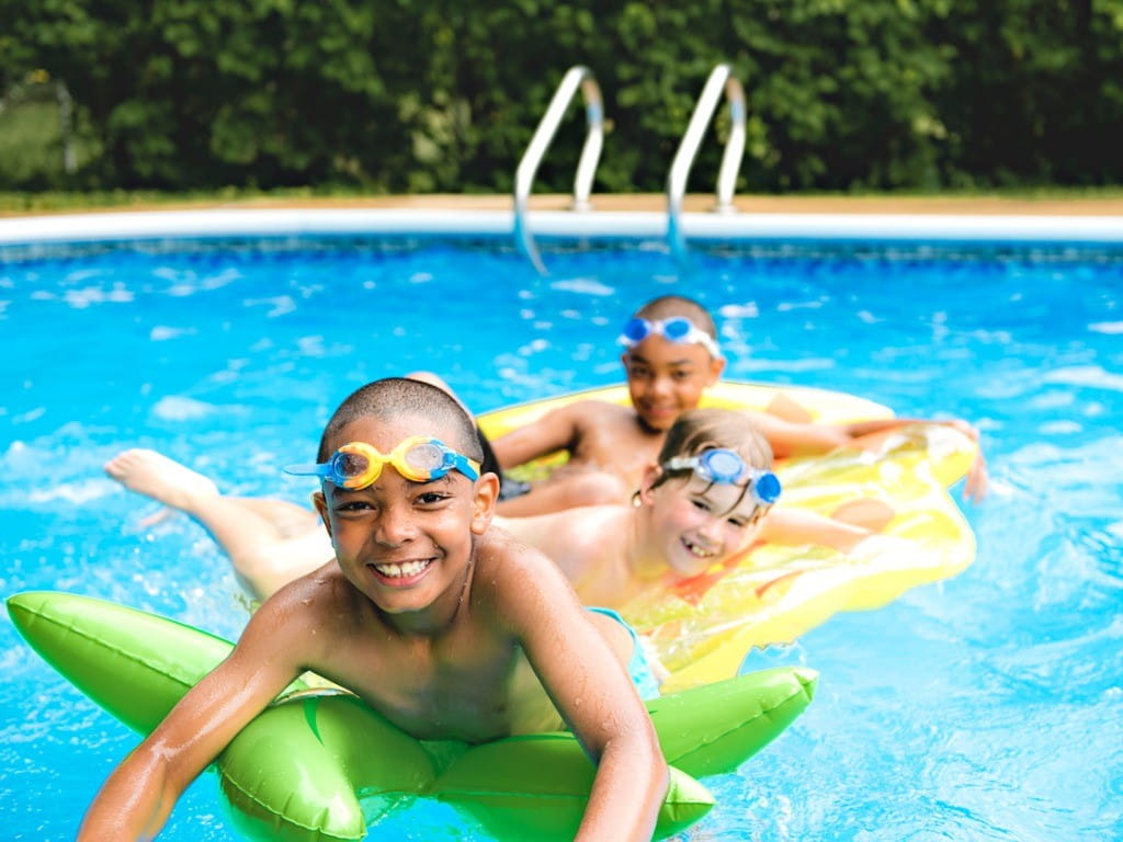 three kids swimming in chlorinated pool