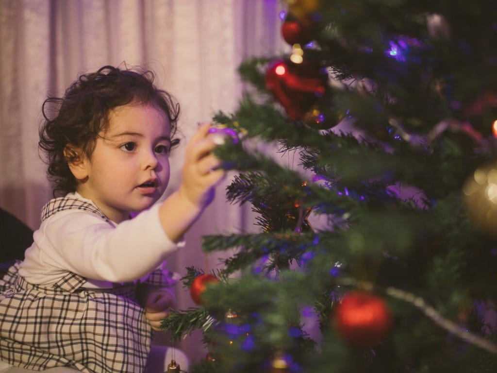 glass ornaments little girl decorating Christmas tree