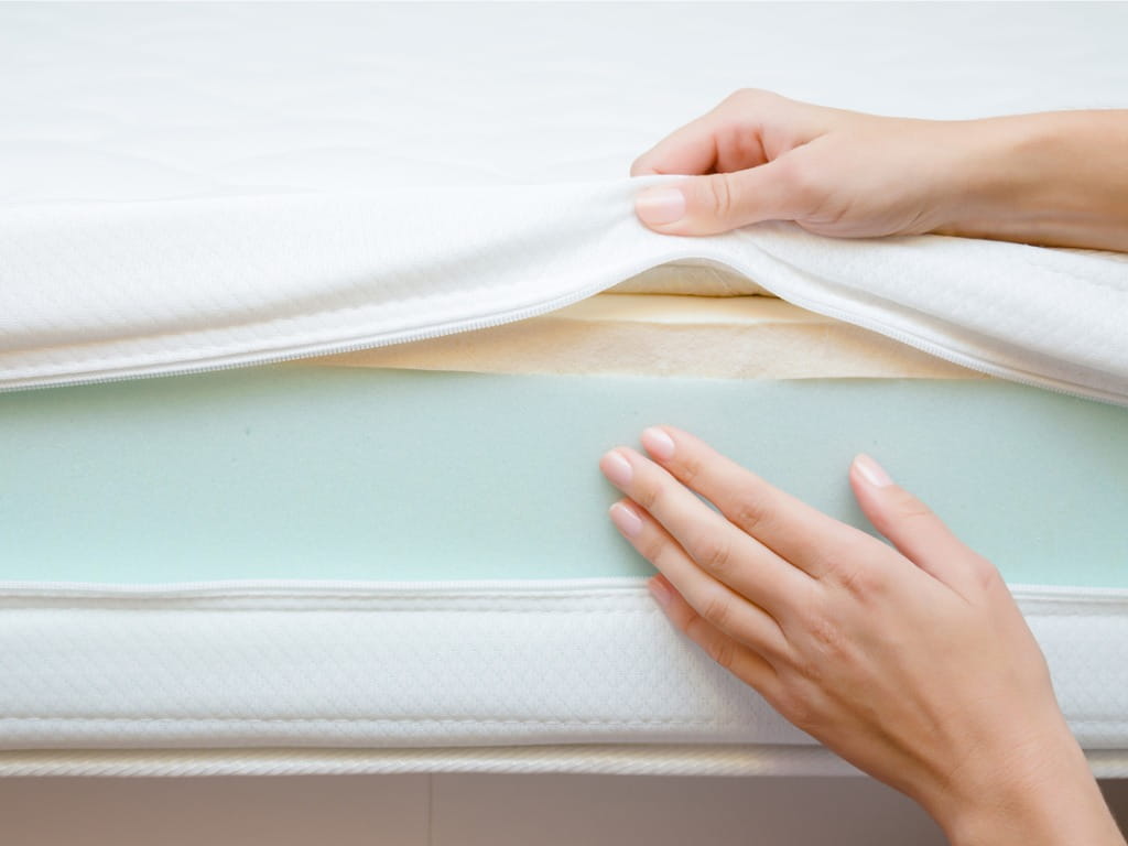 hand touching different layers of a mattress