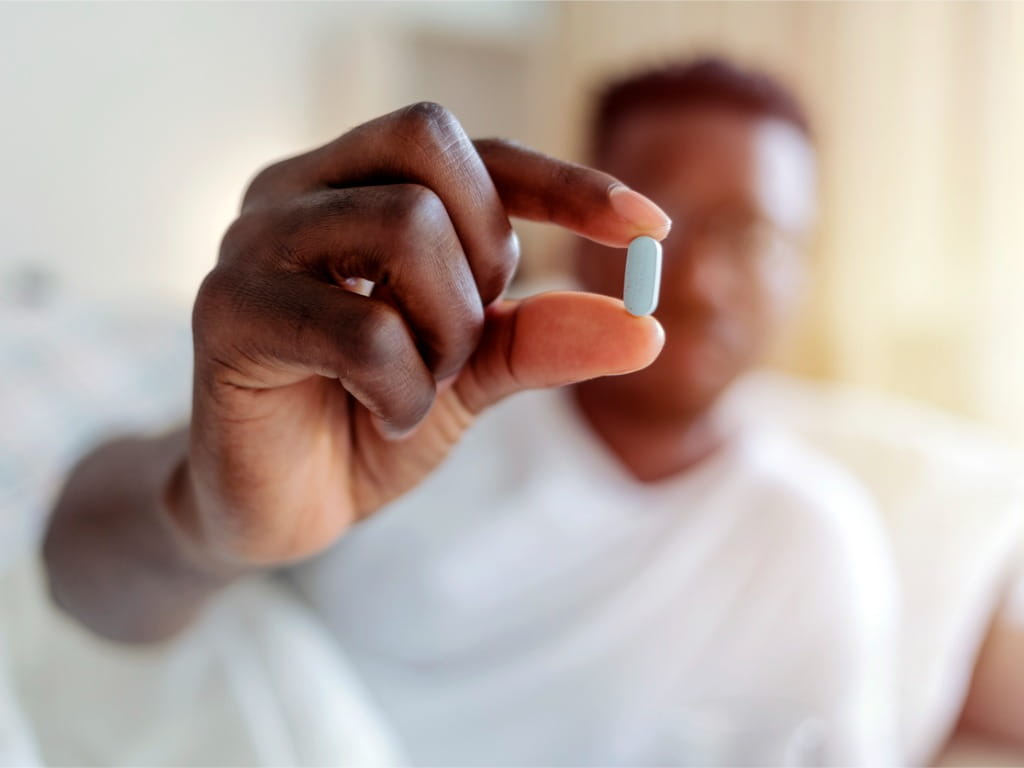 man holding pill to camera