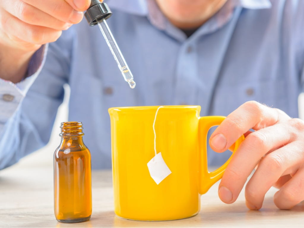 man putting colloidal silver into his drink