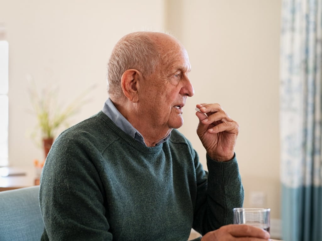 elderly man taking Eliquis® medication
