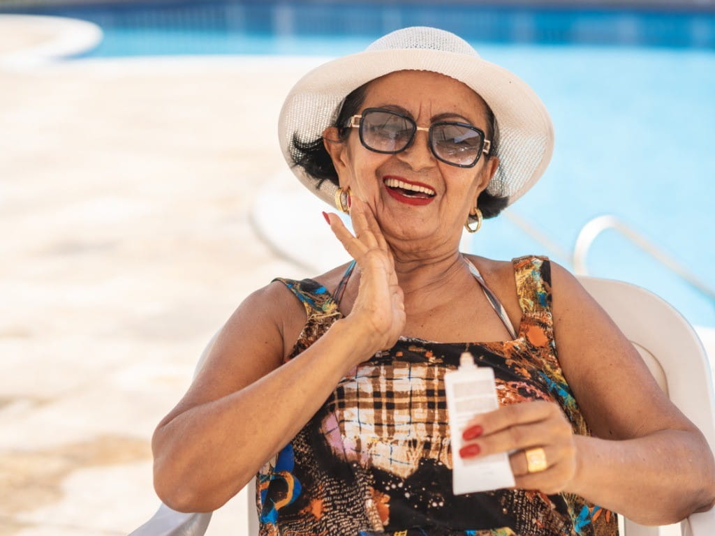 mature woman applying sunscreen