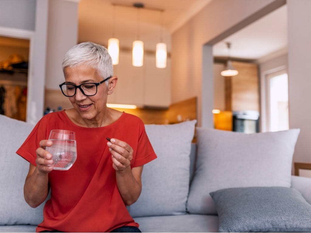 older woman taking methylsulfonylmethane supplement for arthritis