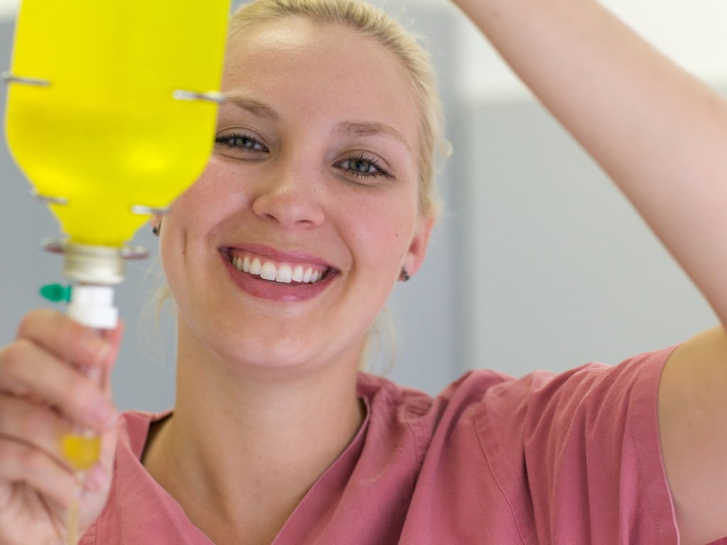 Nurse preparing bright yellow intravenous infusion