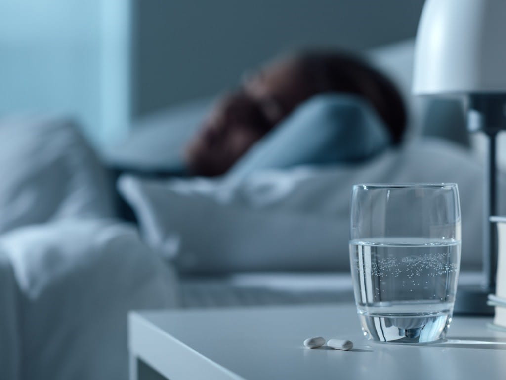 woman sleeping with sleep meds in foreground