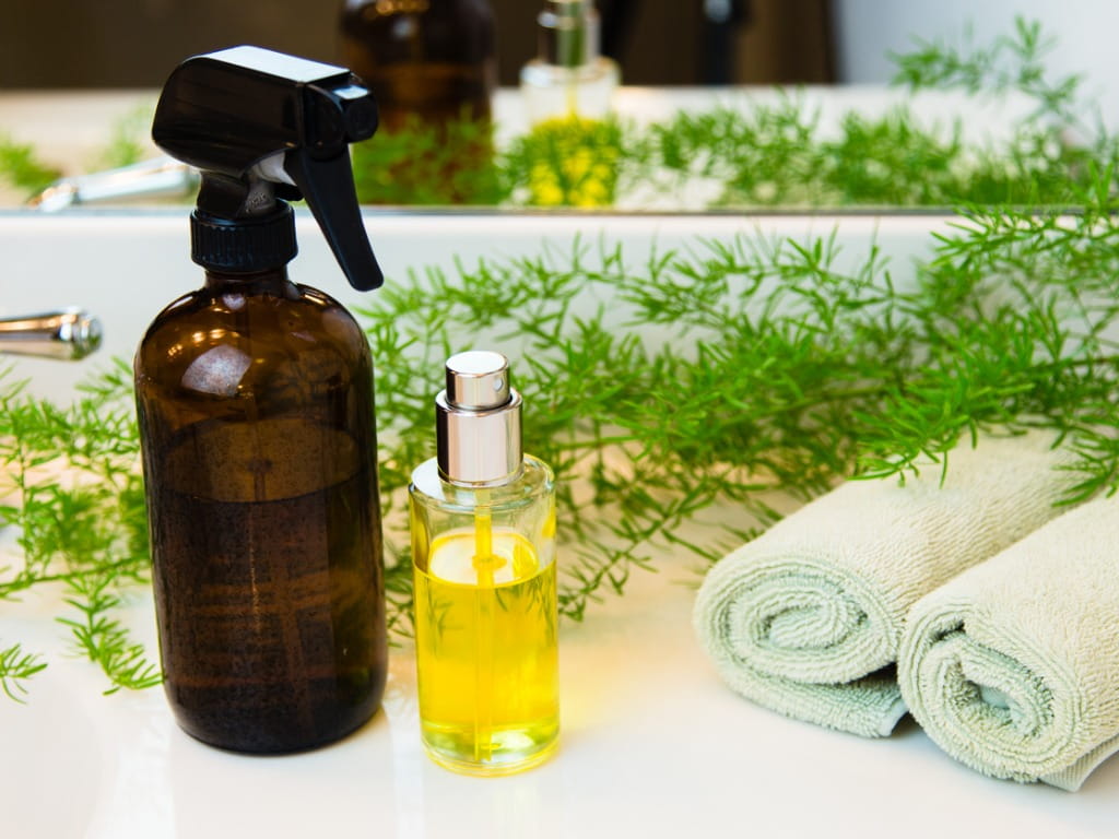 spray bottles and towels next to greenery