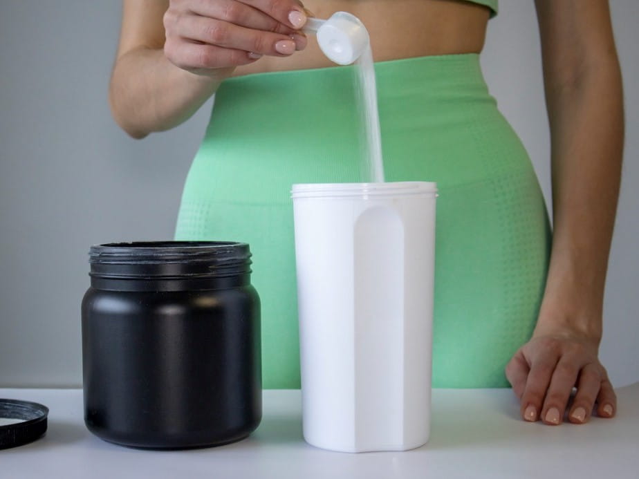 woman adding powder to a drink