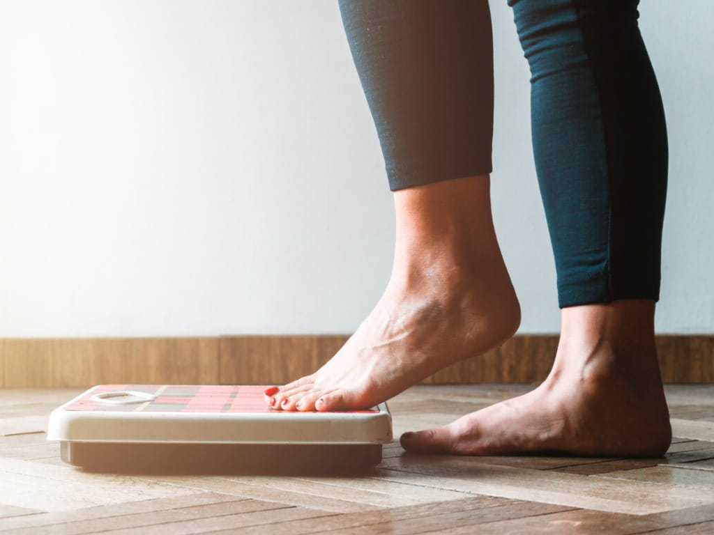 woman stepping on a scale