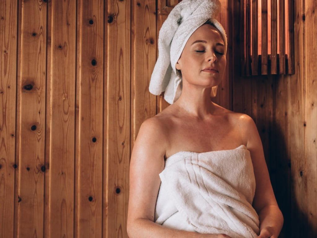 woman sitting in wooden sauna