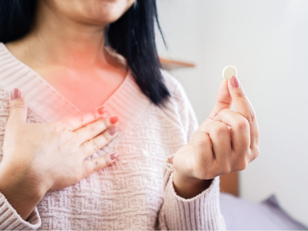 woman taking medicine for heartburn