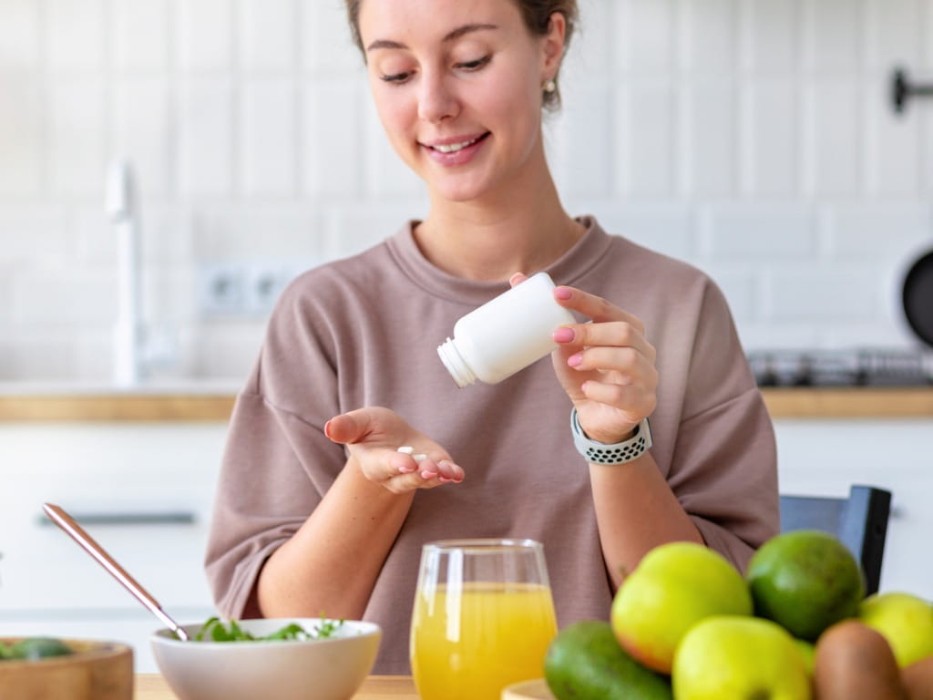 woman taking medicine with food