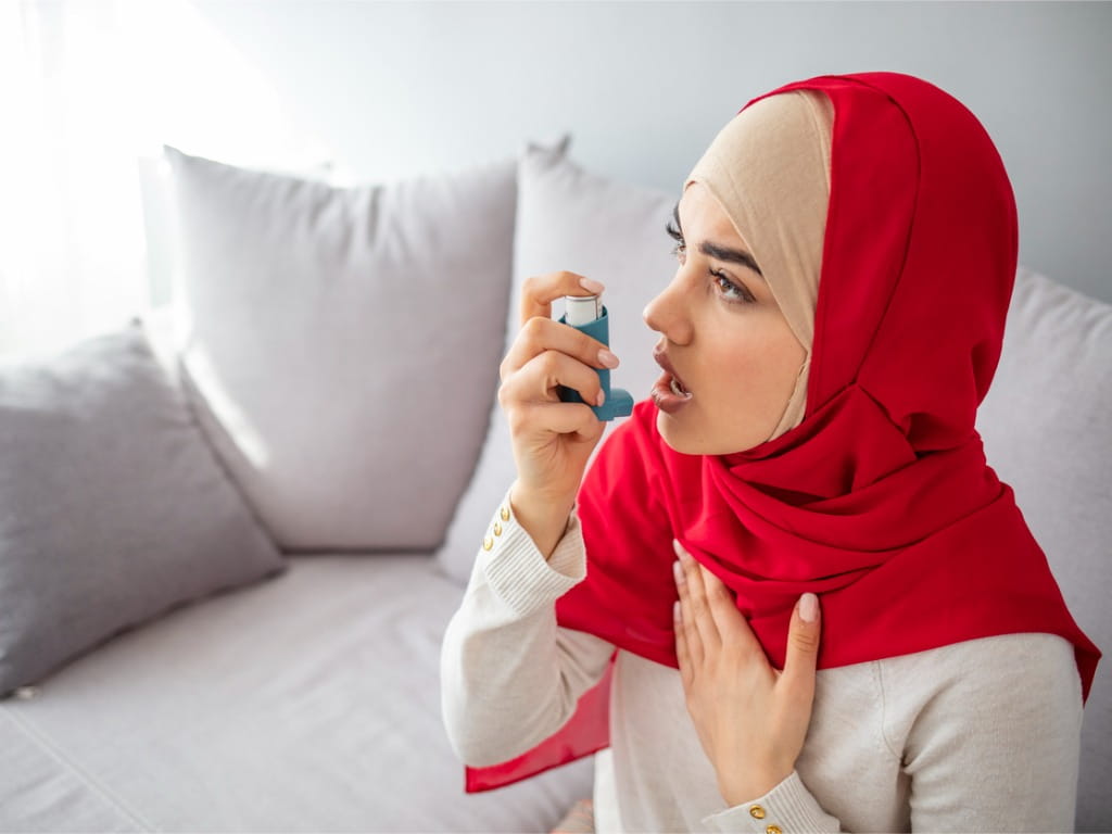 woman using an albuterol inhaler