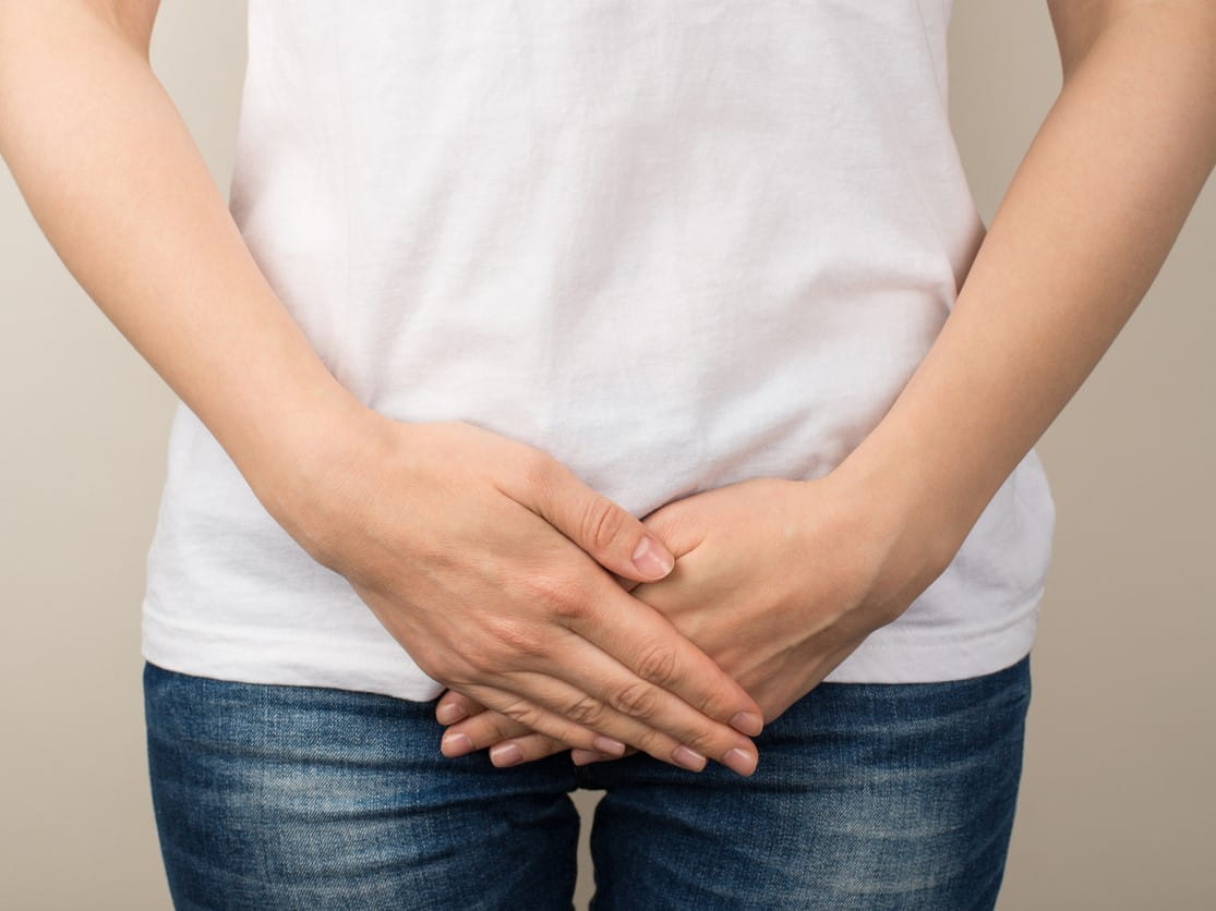 woman holding her hands over her pelvis