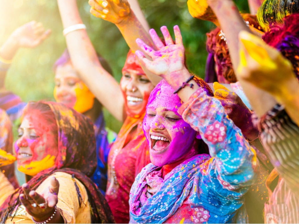 indian women throwing colored holi powder