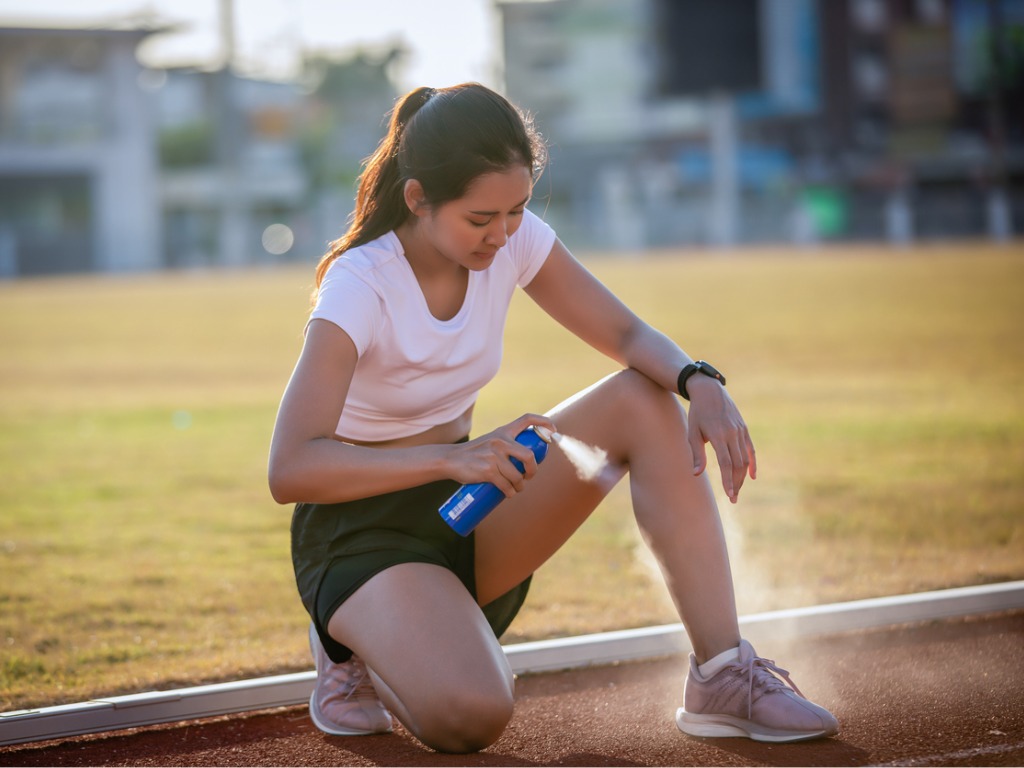 woman using ethyl chloride spray on her leg