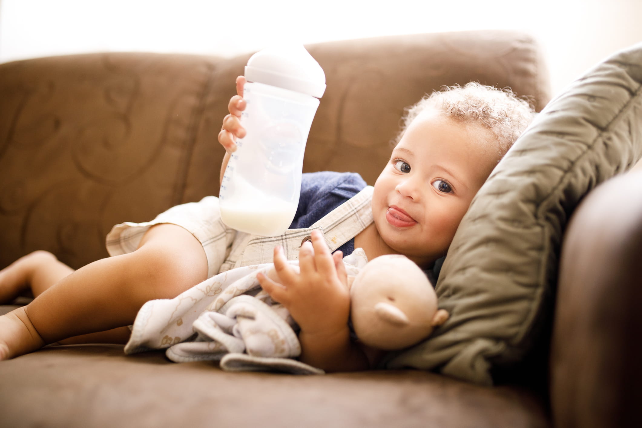toddler holding bottle with formula