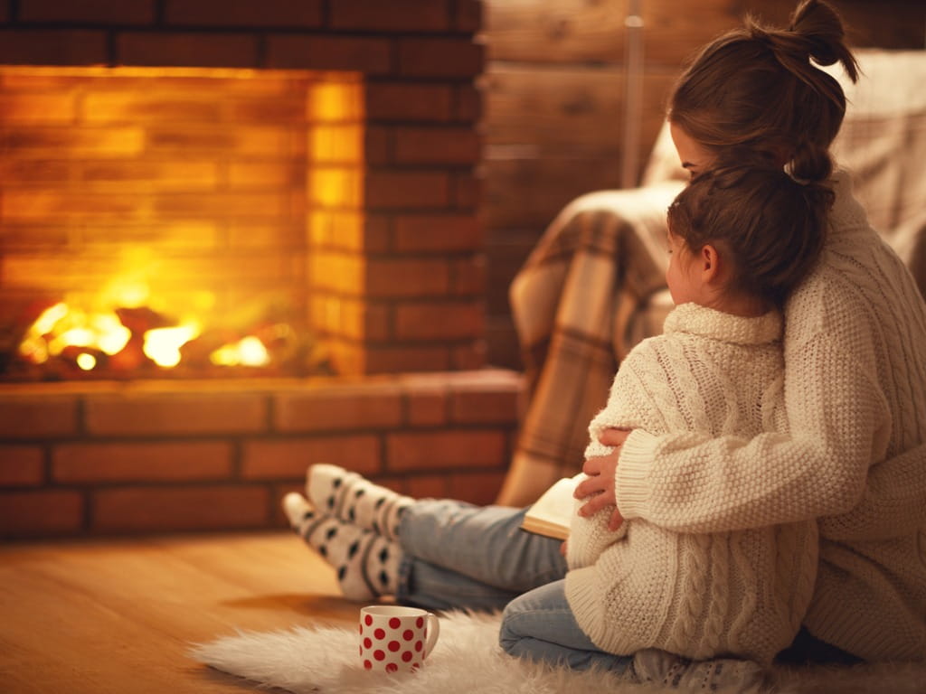 mother and child next to a fireplace