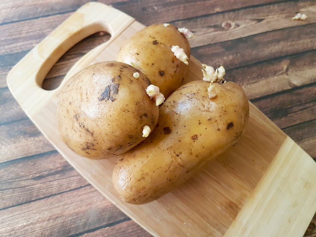 green potatoes sprouted on cutting board